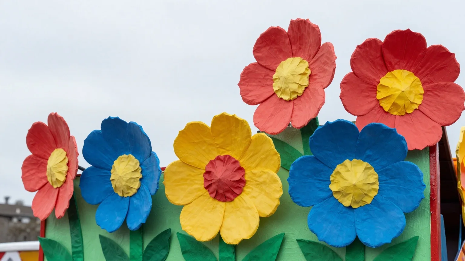 Bunte Pappmaché-Blumen an einem Karnevalswagen in Nahaufnahme