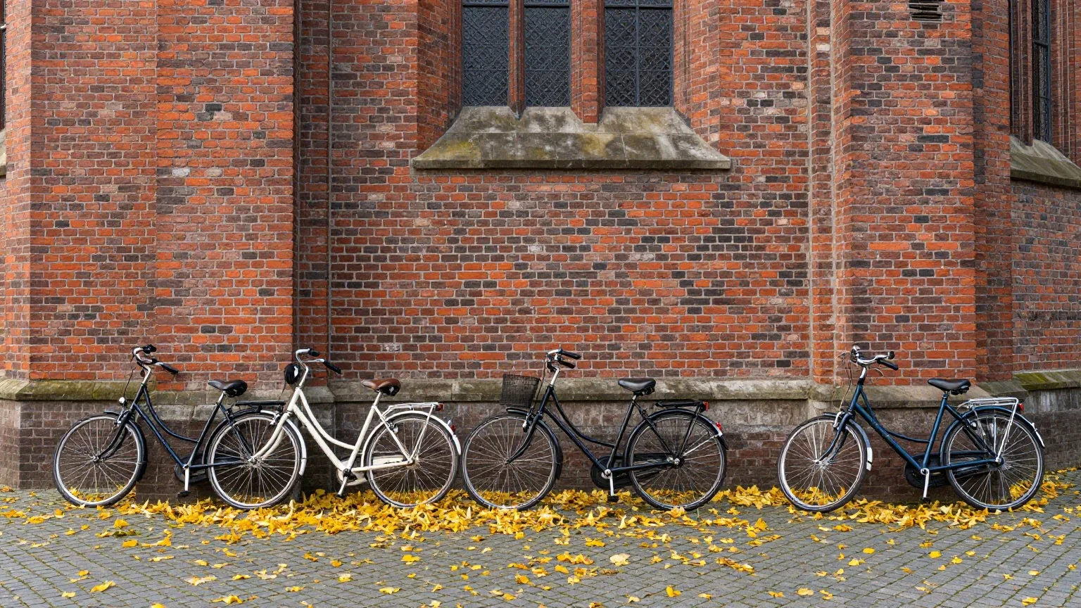 Fahrräder lehnen an der Backsteinmauer einer Dorfkirche an einem sonnigen Herbstmorgen