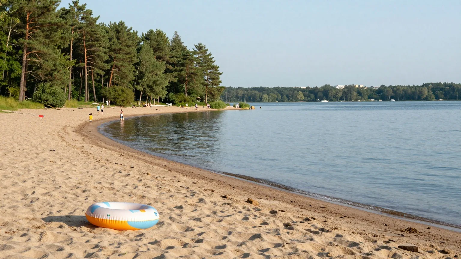 Sandstrand an einem See im Kiefernwald am Stadtrand an einem heißen Julinachmittag