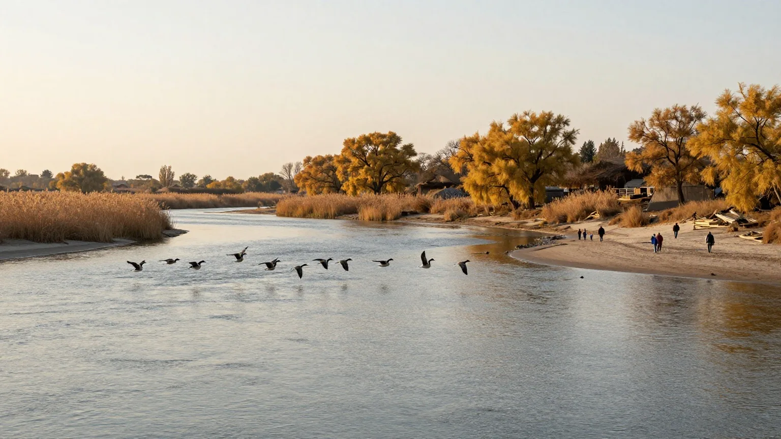 Familie in der Ferne am Ufer eines breiten Flusses mit Sandbänken, darüber ziehende Wildgänse im Herbst