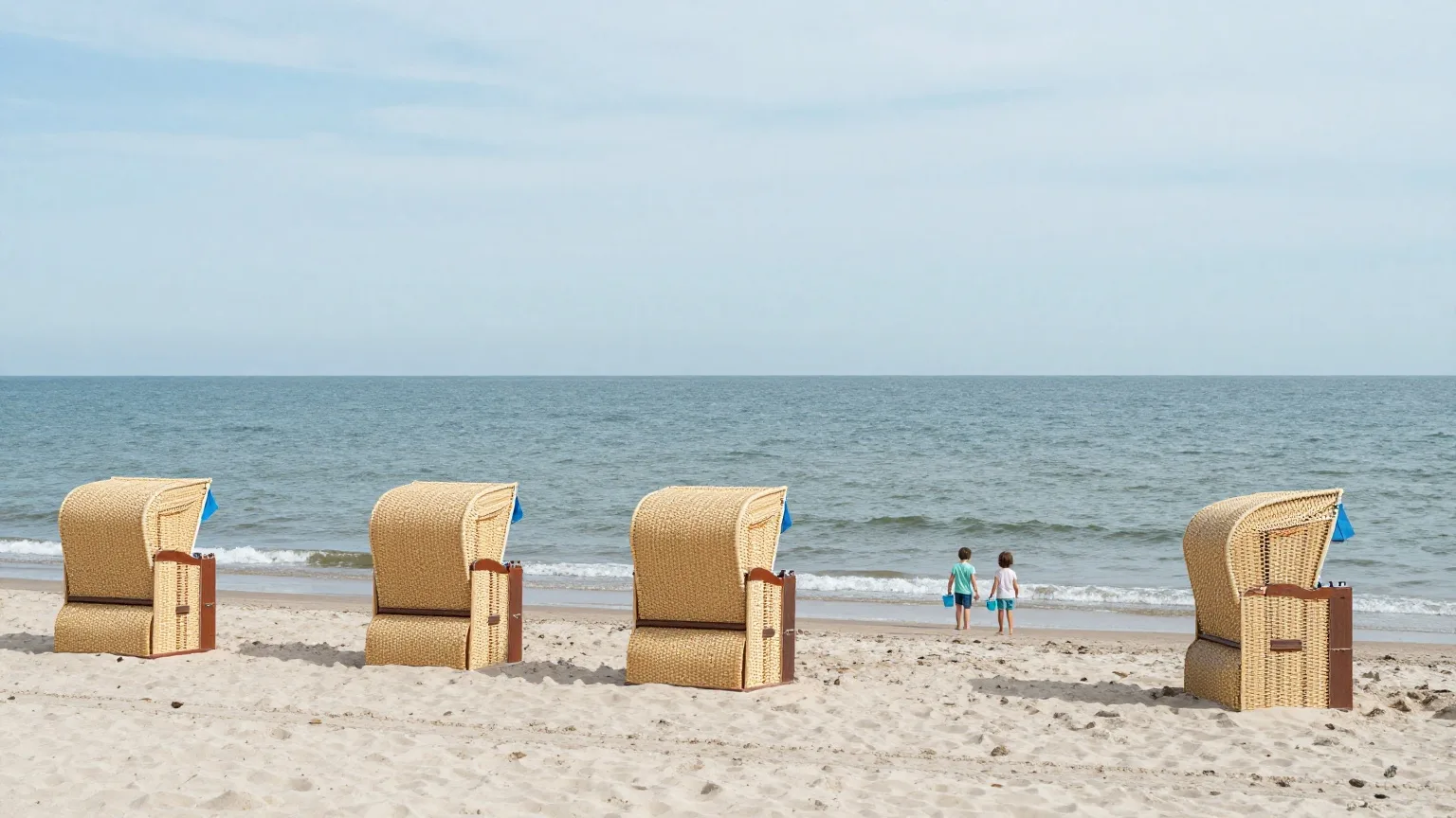 Zwei Kinder von hinten an einem Ostseestrand mit Strandkörben im Sommer